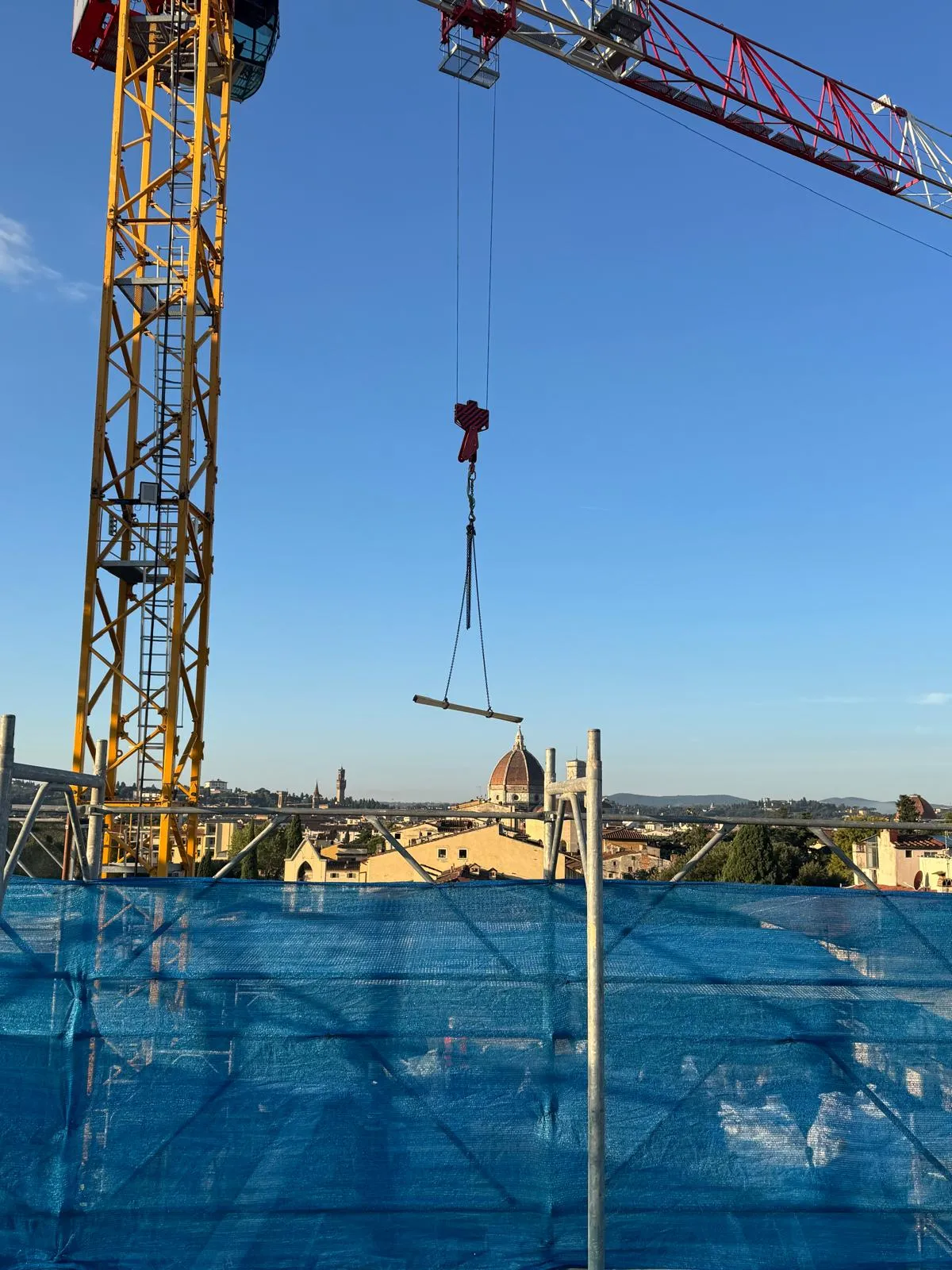 Gru di cantiere FPC Group con una cupola storica sullo sfondo